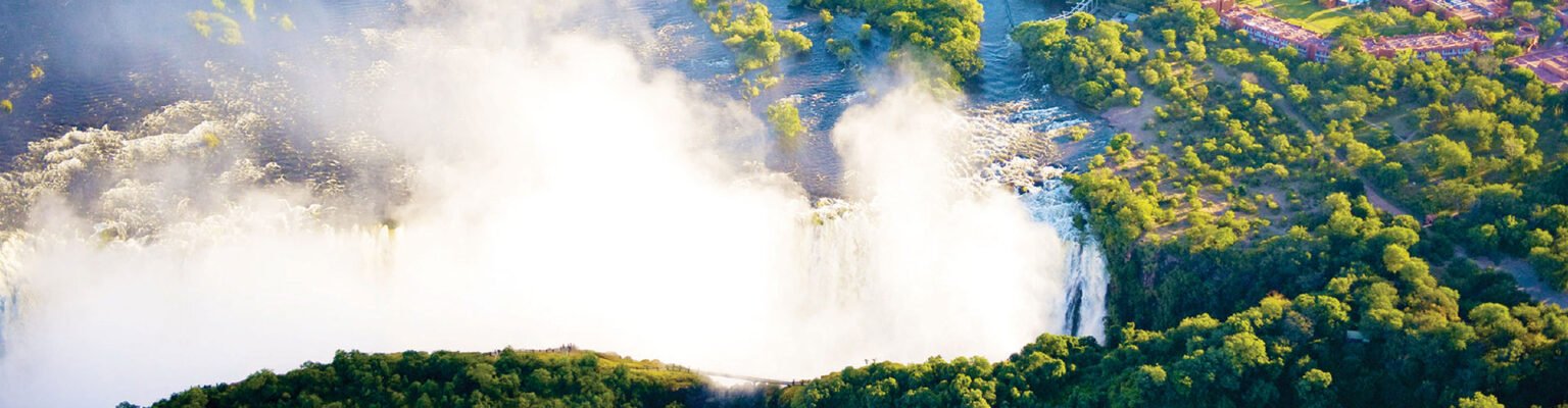Spray rising from Victoria Falls above the forest