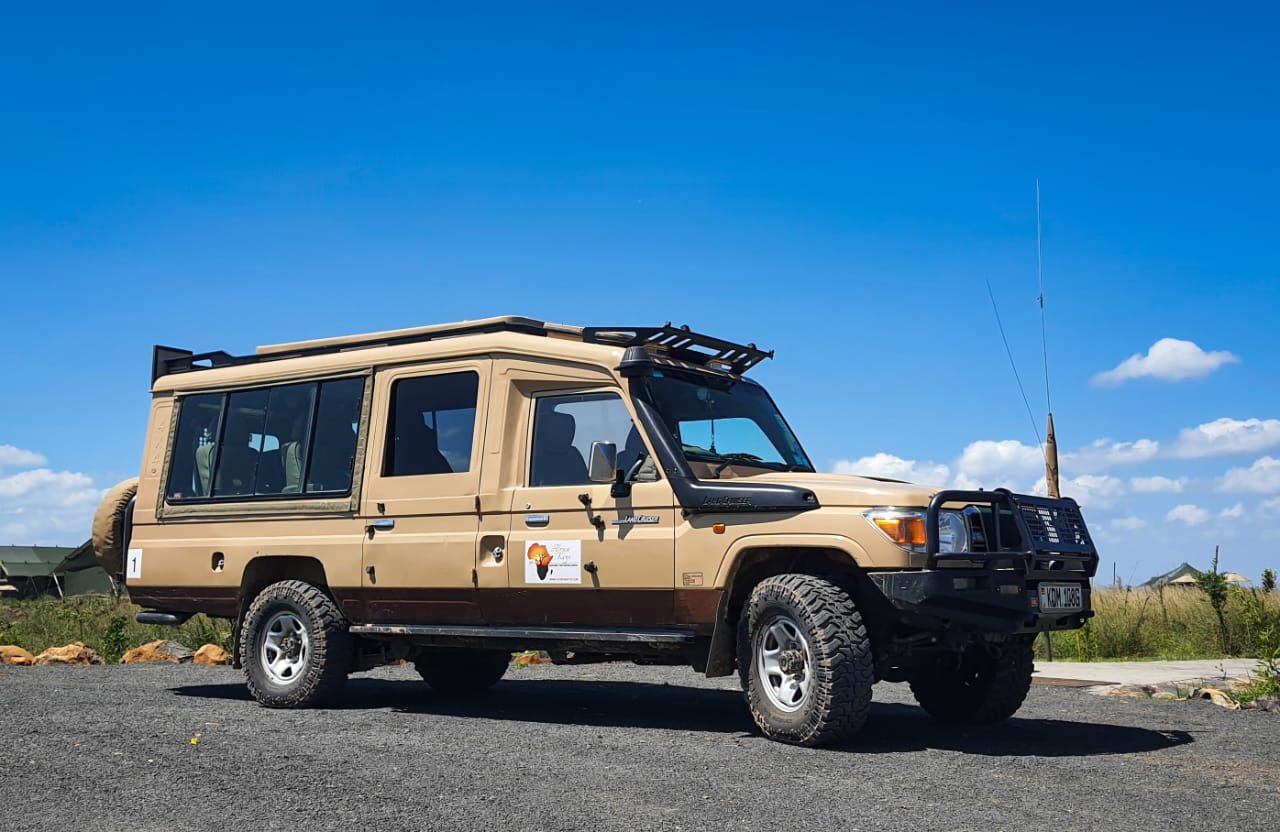 An Africa Keys safari Landcruiser seen from the side on an open road