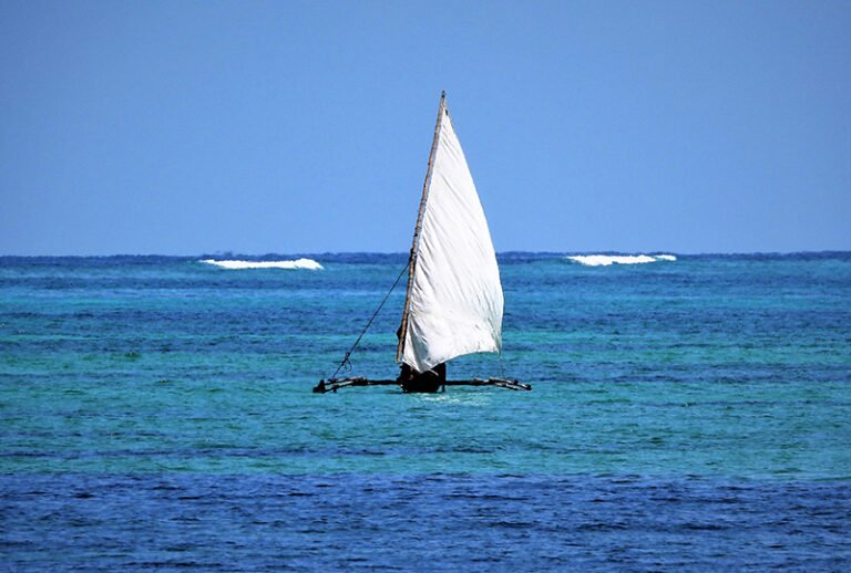 A dhow under sail on blue water off Zanzibar